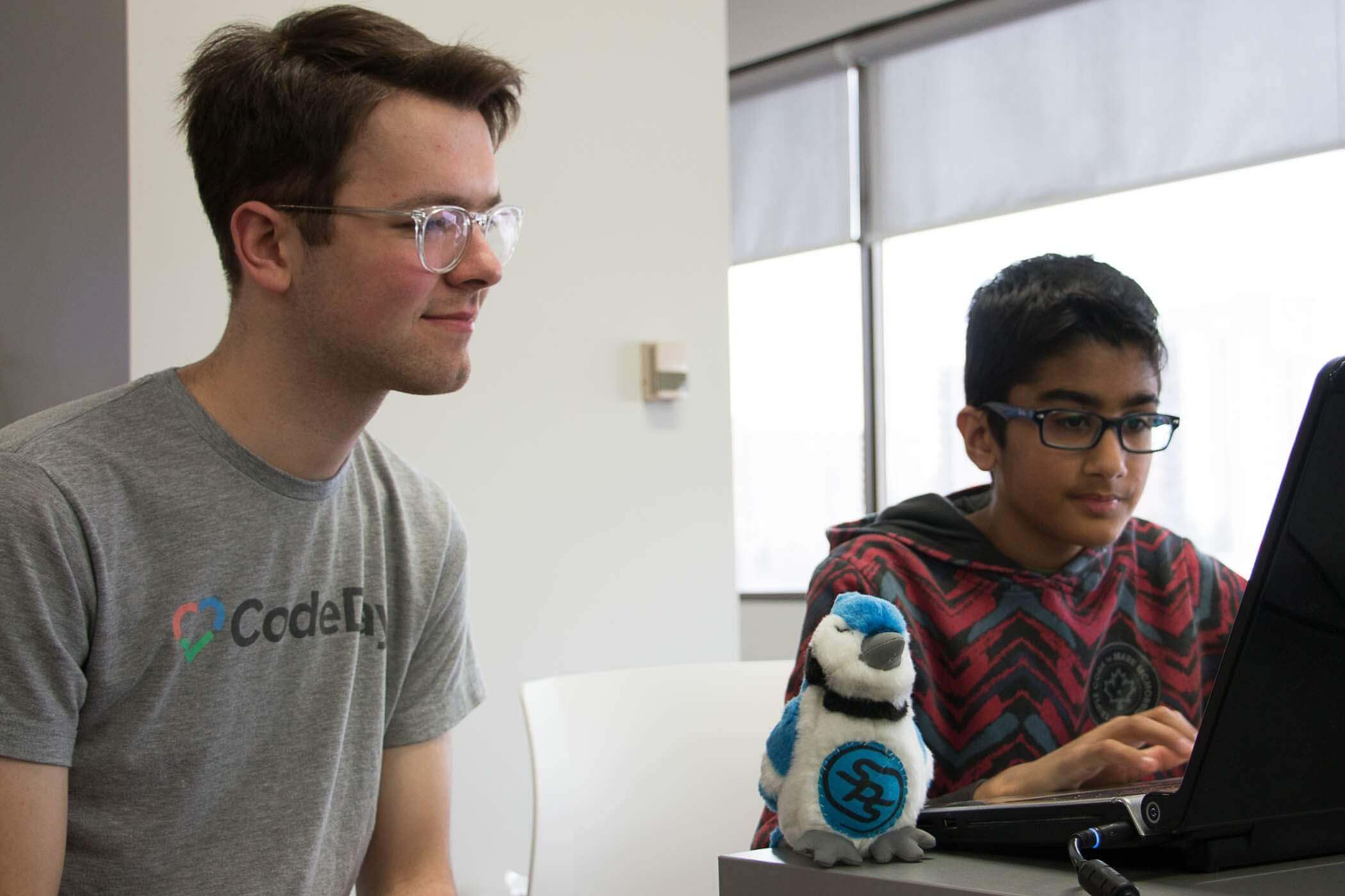 A mentor is helping a studnet learn to code.