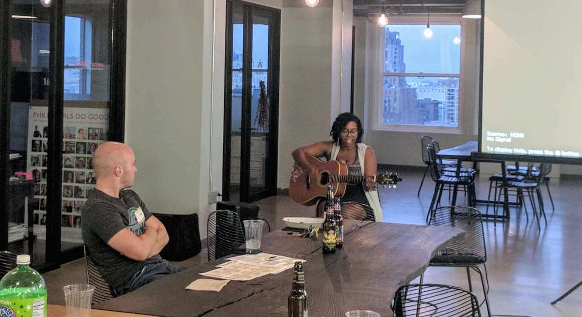 A small audience of 10 people gathered around a presenter